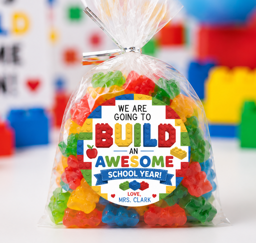 A clear plastic bag filled with colorful gummy candies sits on a white surface, wrapped with a custom printed label that reads 'We are going to build an awesome school year! Love, Mrs. Clark.