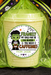 A Halloween-themed candy bucket gift bag filled with pale yellow candy, wrapped in bright green cellophane and tied with a black and green striped bow featuring ghosts and stars. The front has a circular custom label that reads 'FRANKLY MY CHILD MAY BE A CAFFEINE! FROM: JASON' with a cartoon Frankenstein character.