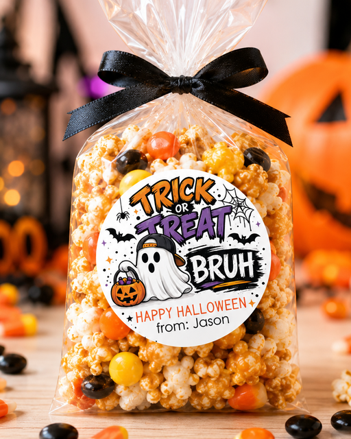 A clear cellophane bag filled with Halloween popcorn and candy, tied with a black ribbon, and labeled 'Trick or Treat Bruh' with a custom 'Happy Halloween from: Jason' note. The bag is set on a wooden surface with scattered candy corn, black candies, and blurred orange jack-o'-lanterns in the background.
