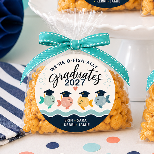 Four bags of popcorn with 'Graduates 2027' labels on a table with party decorations.