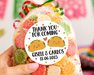 A hand holds a clear plastic bag filled with colorful gummy candies tied with a red, green, and yellow striped ribbon. The bag has a round white label that reads 'THANK YOU FOR COMING' with taco illustrations and the names 'Gisell & Carlos' plus a date.