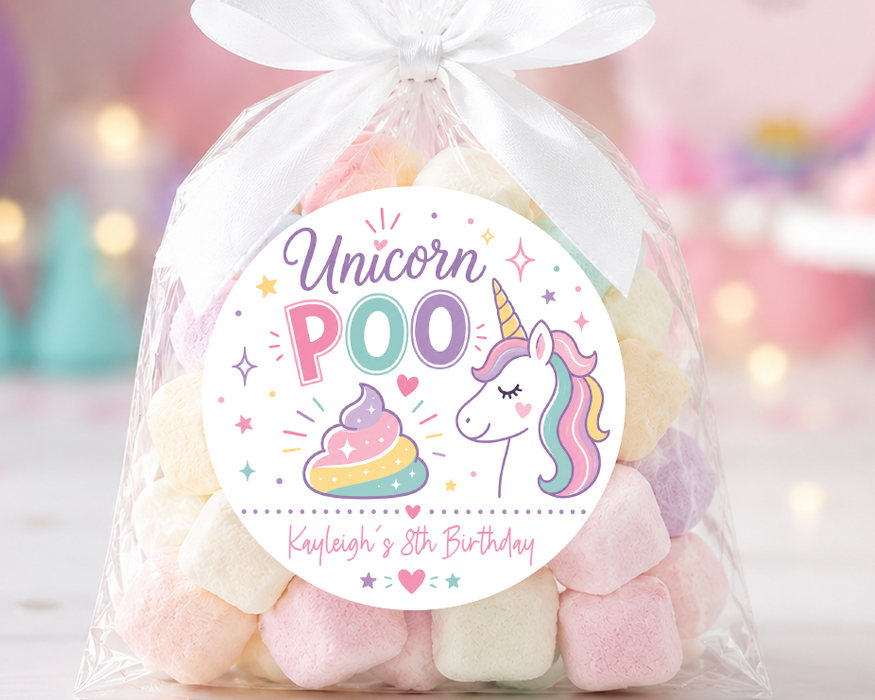 A clear cellophane gift bag tied with a white ribbon, filled with pastel marshmallows and topped with a round 'Unicorn POO' birthday label, set against a soft pink party background with balloons and a unicorn decoration.